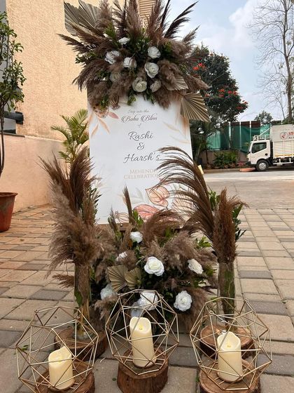 A welcome sign that perfectly matches the boho theme, with pampas grass arrangements and minimalist candles creating an inviting entryway.