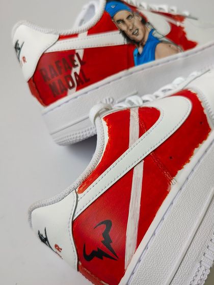 A view of both shoes, showing the Nadal portrait on one and his logo on the other. A simple but powerful tribute to a tennis legend.