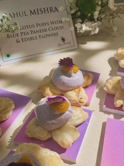 Fashion meets flavour. For Rahul Mishra's flagship store launch, we created canapés as refined as the couture, like these Mini Lotus Puffs with Bluepea Paneer Cloud and edible flowers.