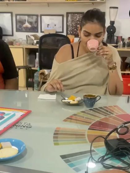 A participant enjoying a cup of coffee paired with Indian sweets during our flavor pairing session. We explore how different foods interact with coffee.