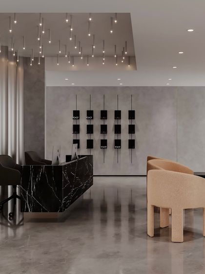 In this reception area, warmth intertwines with elegance. Eclectic pendant lights hang like stars above the bold marble desk, while soft, sculptural chairs provide comfortable seating for visitors.