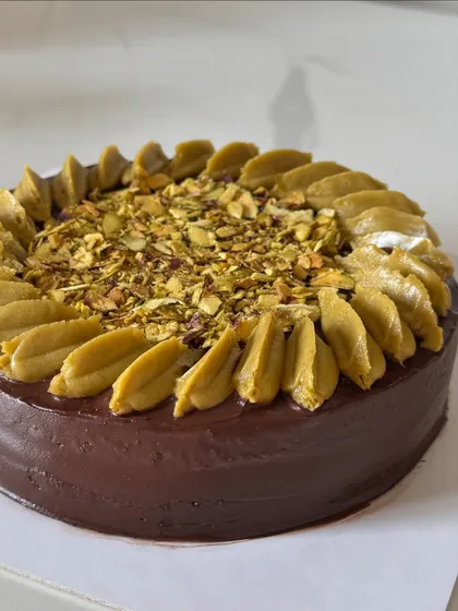 A closer look at the Hazelnut and Pistachio ganache cake, showing the beautiful texture of the piped frosting and chopped nuts.