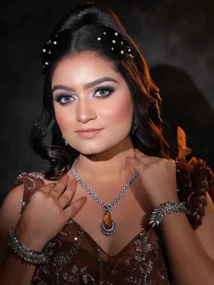 A beautiful portrait showcasing a glamorous party look. The makeup features a soft cut-crease with glitter, paired with a modern hairstyle for a chic finish.