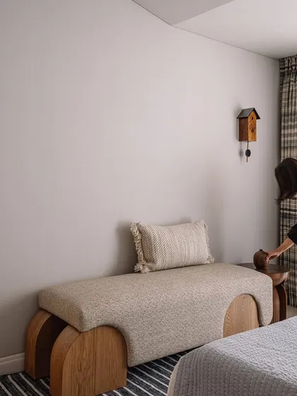 A custom-designed bench at the foot of the guest bed adds another layer of texture and form to the room. The cuckoo clock is a whimsical touch that reflects the clients' personality.