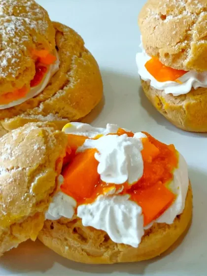 My mango cream puffs are light, airy, and bursting with flavour. I fill crisp choux pastry shells with a delicate whipped cream and fresh mango pieces, then dust them with powdered sugar.