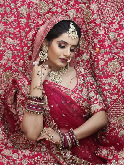 This Banarasi bridal look is all about timeless elegance. The rich red lehenga is complemented by soft, glowing makeup and traditional jewelry.