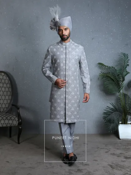 Every petal embroidered by hand. This powder blue sherwani is not fashion, but art. Its aura is fulfilled when the turban and sarpech rest upon it, turning a man into the image of royalty.