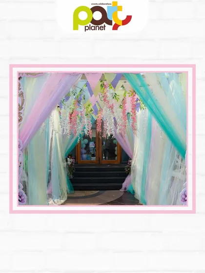 The entrance to a Royal Ball, draped in pastel fabrics and hanging wisteria, creating a dreamy and elegant passageway for young royalty.