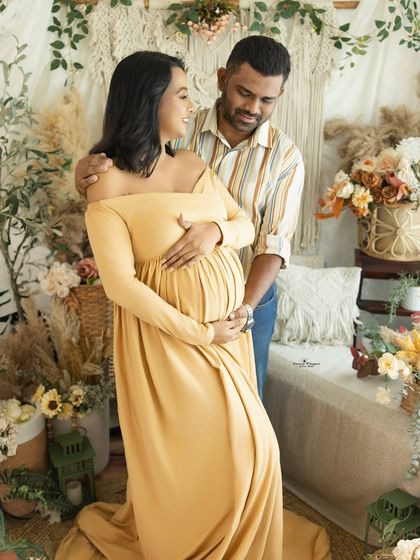 A sweet couple's portrait in our earthy studio setup. The mustard yellow gown and the partner's casual attire create a relaxed and loving vibe.