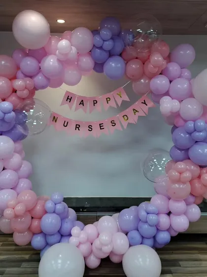 A beautiful circular balloon arch in pastel pink and purple for a Nurses Day celebration. We can create custom shapes and themes for specific industry events, like those for hospitals or clinics.