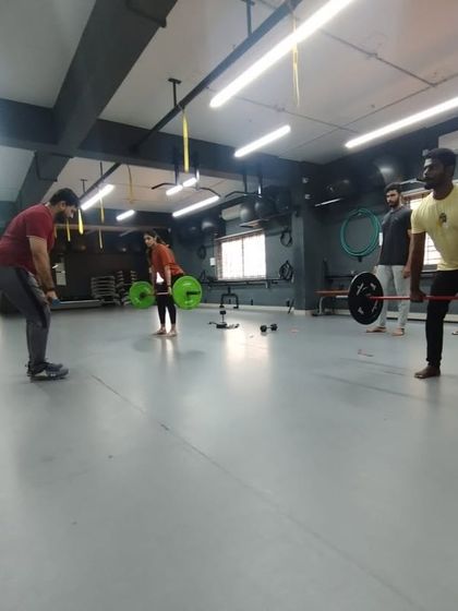 Students learning the mechanics of a deadlift. Our practical classes emphasize safety and proper form for major compound lifts.