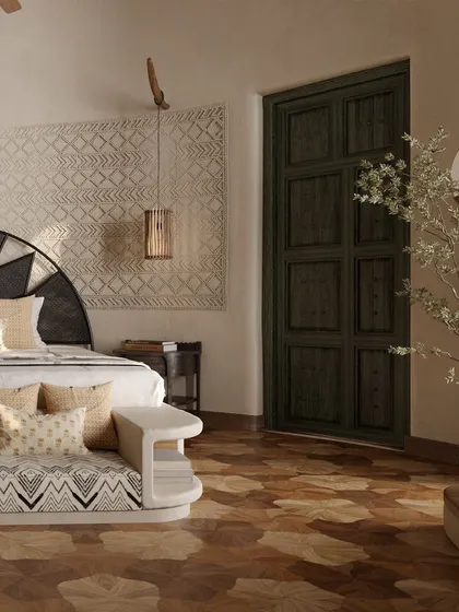 Every detail is considered, from the patterned fabric on the bench to the dark wood of the door. The interplay of light and shadow across the intricate wooden flooring adds depth and character to the space.