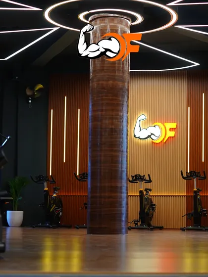 A wide view of our spin studio and group exercise area. The modern design, with its unique lighting and wood-paneled pillar, creates an energizing and premium workout environment.