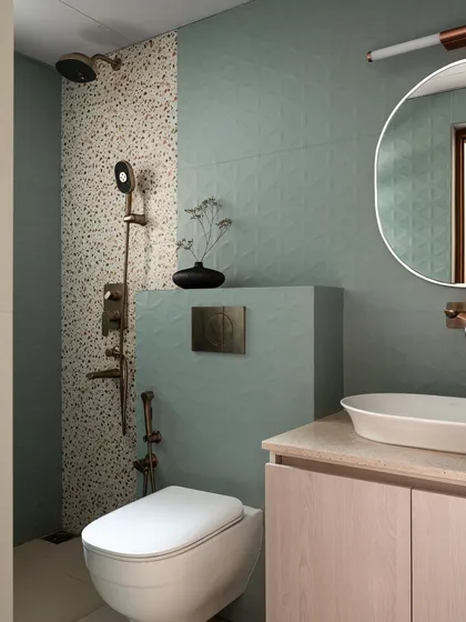 In another bathroom, I used textured sage green tiles and terrazzo to create a spa-like feel. The blush-toned vanity adds a soft, unexpected touch of color, complemented by brushed bronze fixtures.