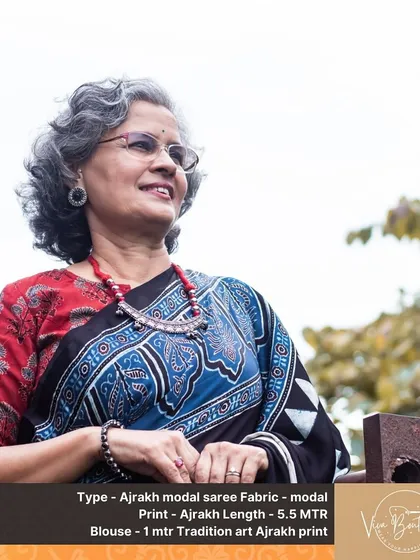 A lovely customer looking radiant in our black Ajrakh modal saree with beautiful blue and red block print details. It’s paired with a simple red blouse and traditional jewelry for a complete look.