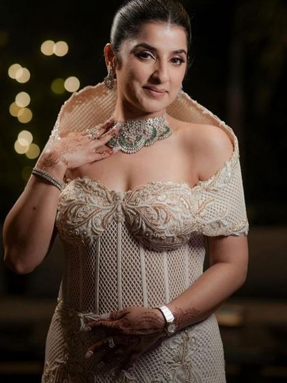 A masterfully sculpted corset gown in ivory, an ode to contemporary couture with its sharp tailoring and structured hood. It celebrates both form and femininity.