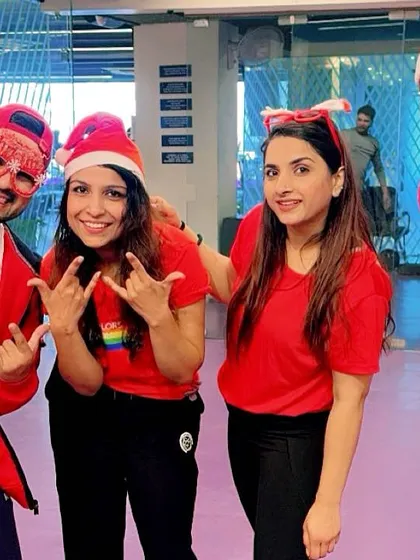 Posing with my awesome students during the Christmas celebration. The red theme and festive props add to the fun.