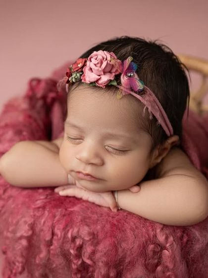 A sweet close up that captures the baby's peaceful expression and the delicate details of her floral headband.