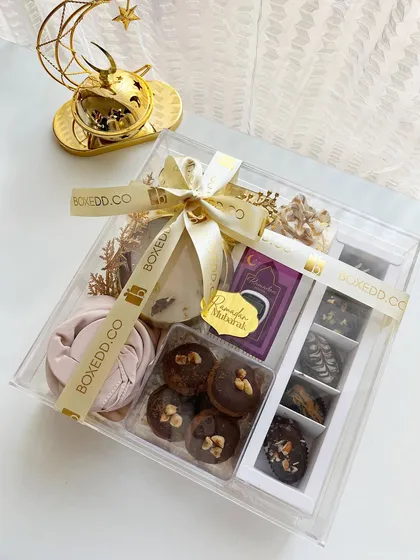 The complete acrylic Ramadan hamper, featuring a scented candle, a rolled scarf, and gourmet dates.
