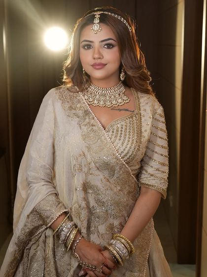 A full-length view of the ivory and gold lehenga, showcasing its grandeur. This is a perfect rental for a majestic wedding look.