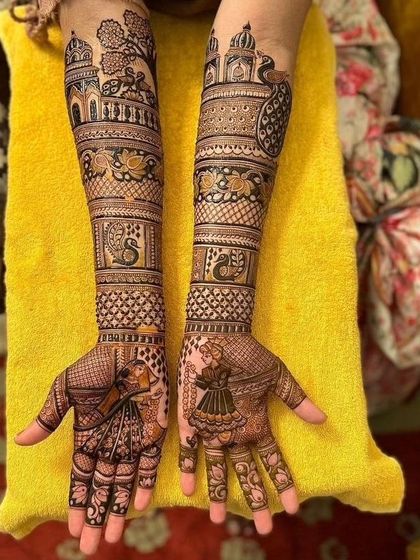 A beautiful example of storytelling mehendi, with a bride and groom on the palms, and scenes of a royal procession with peacocks and palaces on the arms.