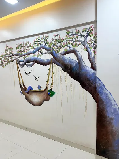 An angled view of the Baby Krishna mural, showing how it wraps around the corner of the wall.
