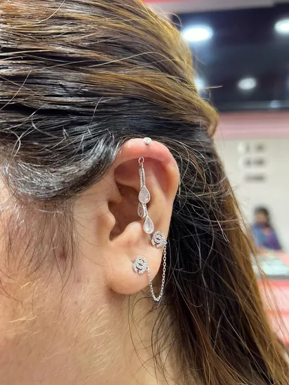 This look is all about delicate movement. A triple-teardrop hanging is paired with a double-stud connected by a fine chain.