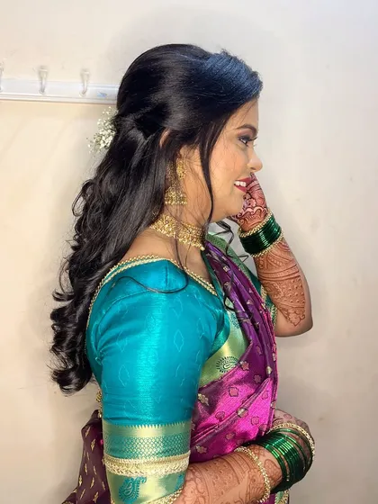 A side profile of the engagement bride, showing her soft curls and the flawless, natural-looking skin finish.