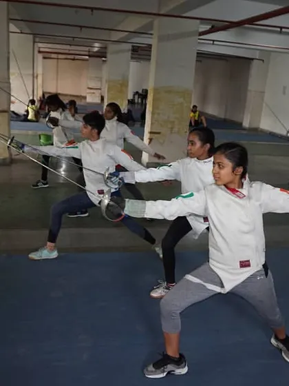 Discipline in motion. A group of our young female fencers execute synchronized lunges during a footwork session, building the muscle memory and precision required for competitive bouting.