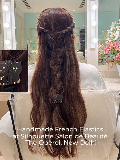 A beautiful braided half-up style featuring a handmade French kitten elastic. This accessory is gentle on the hair and adds a touch of playful charm.