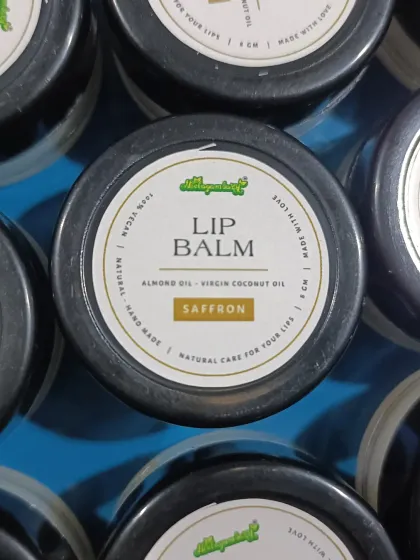 A top-down view of our Saffron Lip Balm. The label clearly states the natural ingredients like almond oil and virgin coconut oil. It's simple, honest, and effective.