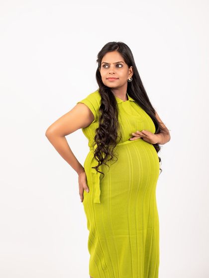 A confident and stylish pose from this mom-to-be during her studio maternity session. The lime green dress adds a fresh and modern feel to the portrait.
