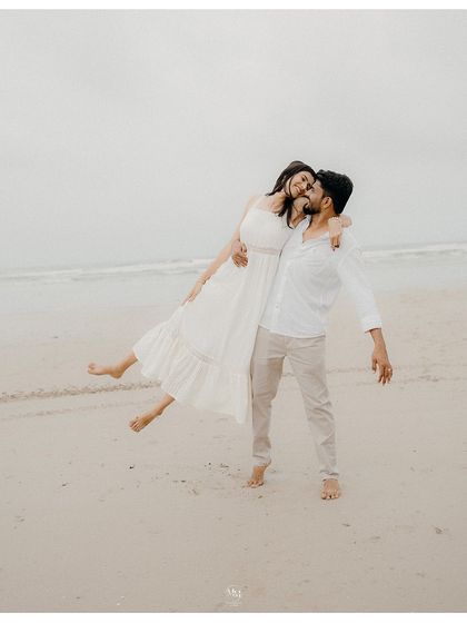 He lifts her up effortlessly on the beach, a moment of pure joy and strength in their relationship. Her laughter and the ocean breeze make this a perfect candid shot.