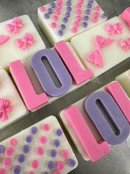LOL! These cute soaps were made for a 7-year-old's LOL Doll-themed birthday party. The set includes soaps with the LOL logo, polka dots, and pink bows.