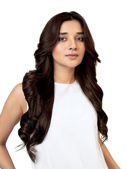 A model showcasing a beautiful, deep mocha brown color. The hair is styled in classic, glamorous waves, demonstrating a timeless yet bold look.