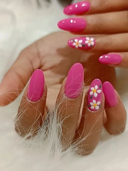 A still image of the vibrant pink manicure with cute, hand-painted daisy art.