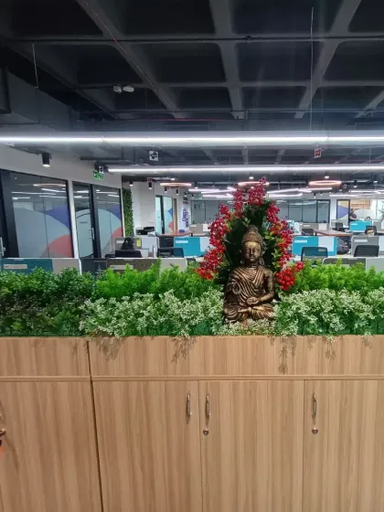 I added a Buddha statue among the artificial plants in this office planter, creating a point of interest and a sense of calm in the busy workspace.