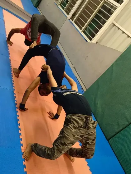 A three-person backbend train. This is a fun and challenging partner exercise that improves flexibility and requires a lot of teamwork.