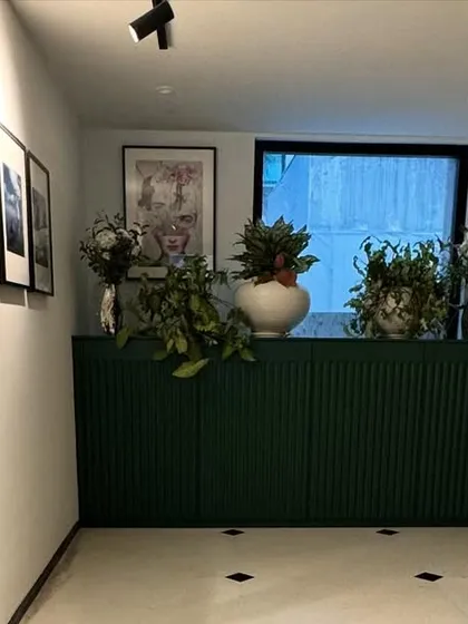 For this entryway, we designed a deep green console with fluted paneling to add texture and a bold splash of color. It serves as a beautiful and practical storage solution, making a strong first impression.
