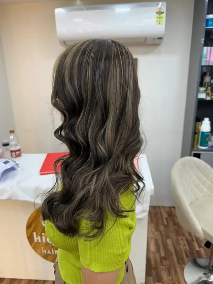 Ash blonde highlights styled into soft waves. This look is perfect for adding a cool, modern touch to your hair.