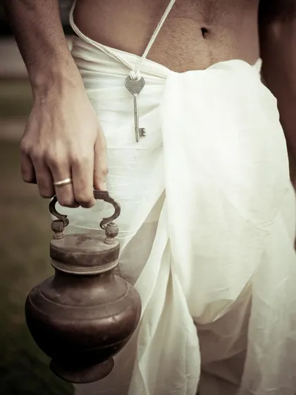 A detailed close-up for Sanchit Sharma, focusing on the styling elements. The image highlights the texture of the fabric, a traditional vessel, and a key accessory.