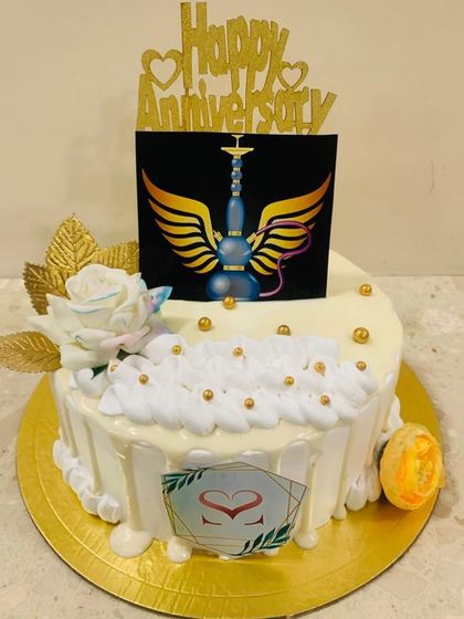 A sheesha lover special anniversary cake, featuring a winged hookah design on a white drip cake.
