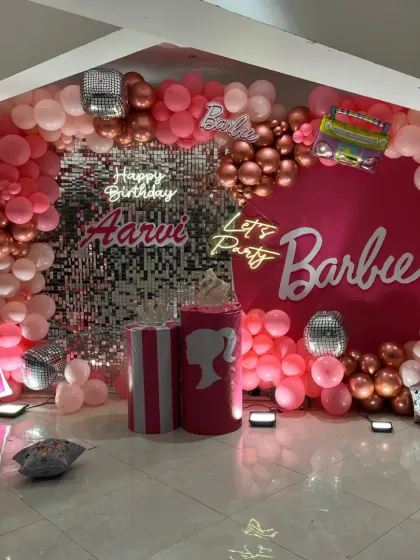 We brought the popular Barbie theme to life for this first birthday party. The decoration features a stunning pink balloon arch, a silver sequin wall for extra sparkle, multiple neon signs, and custom Barbie-themed props, creating a glamorous and fun party setting.
