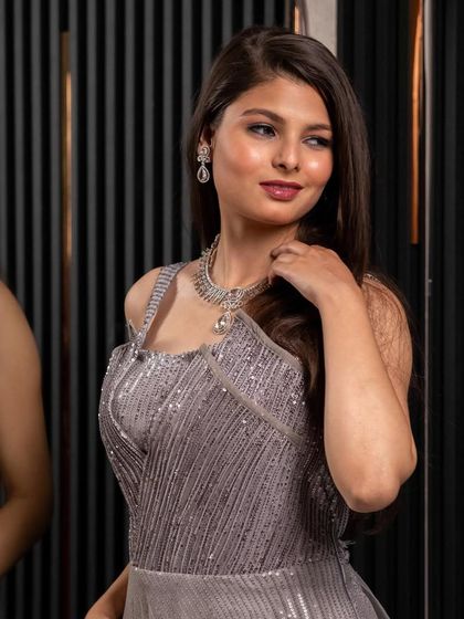 This grey sequined gown offers a sleek and glamorous look. The subtle shimmer and flattering silhouette make it a sophisticated choice for an evening reception or cocktail event.