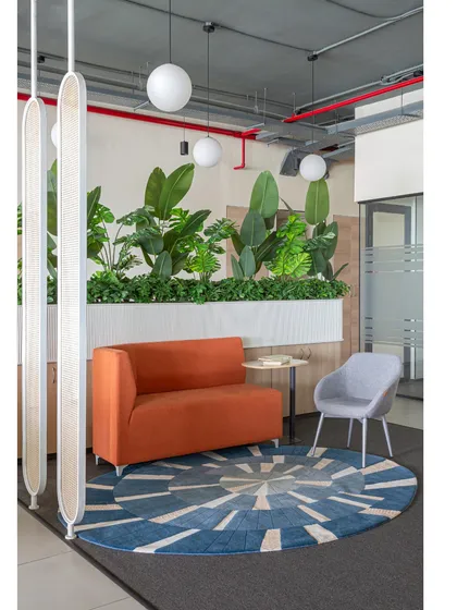 This central breakout area is one of my favorite spots in the office. It features a mix of seating, including a comfortable sofa and accent chair, perfect for informal meetings or a quiet break.