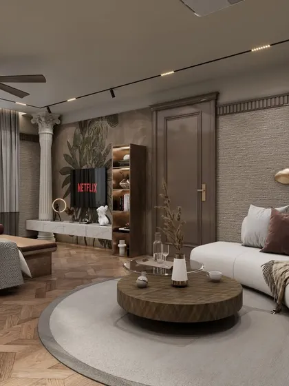 The bedroom includes a spacious seating area with a curved white sofa and a round coffee table. Classical columns and decorative wall art add character and a sense of grandeur to the space.