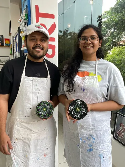 A couple with their finished dot mandala pieces. It's a relaxing and mindful activity to enjoy together.