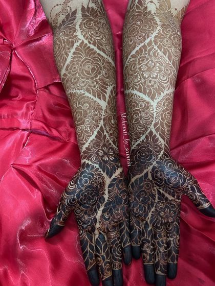 This design combines bold, dark-stained florals on the palms with lighter, intricate patterns on the arms. This contrast creates a stunning effect that is both modern and traditional.