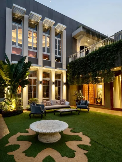 Even in the heart of the city, you can have a tranquil outdoor sanctuary. I transformed this urban bungalow's courtyard into an elegant evening lounge, using strategic lighting on palms and a patterned lawn to create a sophisticated and private green space.