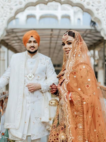 A beautiful shot focusing on the bride, with the groom slightly behind her, capturing her confident and radiant look.